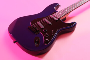 Modern electric guitar on pink background