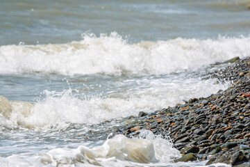 Fototapeta premium Sea water splashing over the stones on the beach