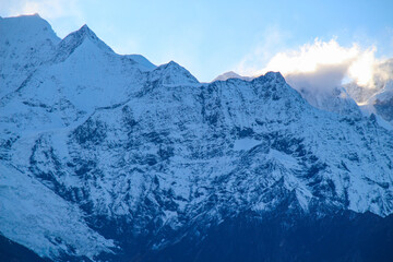 Obraz premium Jagged, snowy peaks loom under a cloudy sky Yala Snow Mountain, Sichuan, China