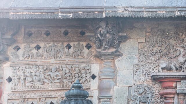 Pan: Detailed stone carving Halebeedu ancient temple Karnataka India showing warriors deities animals intricate sculptural art symbolizing heritage culture devotion
