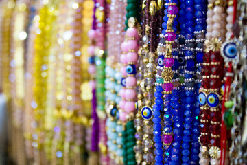 Hanging rows of brightly colored bracelets and beads, the focus is on the 