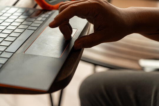 Hand holding stylus writing on tablet in a cozy cafe environment, symbolizing digital creativity, remote working, coffee shop lifestyle, and modern technology-driven workspace.