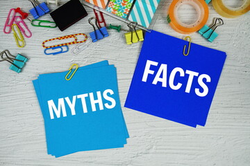 Myths vs Facts text on stick note with stationery on concrete background