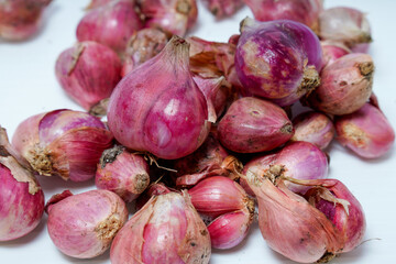 close up view of a pile of fresh red onions isolated in white for advertising space.
