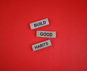 Wooden Blocks With 'Build Good Habits' Text on Red Background