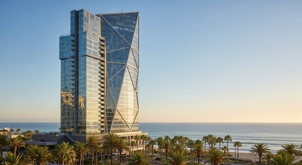 Striking modern architecture by the sea with palm trees in the foreground at sunset offering a