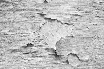 The texture of gray cracked whitewash on a concrete wall. Old peeling plaster