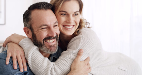 Fototapeta premium Happy, hug and mature couple in home with love, bonding or connection in marriage together. Smile, relationship and woman embracing man with support, safety and sweet moment in living room at house.