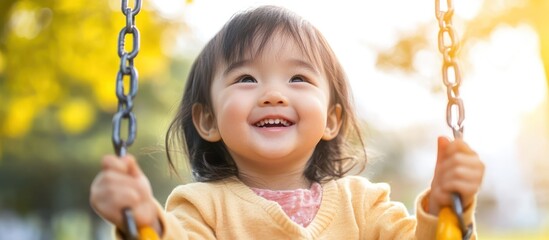 Smiling Young Child Riding Swing in Sunny Outdoor Park