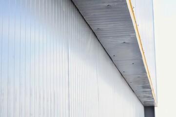 Architectural detail: Corrugated metal siding on a building's exterior, minimalist and clean.