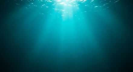 Obraz premium Underwater sun rays illuminate the deep blue ocean, creating a serene marine background with graceful rays swimming through the light