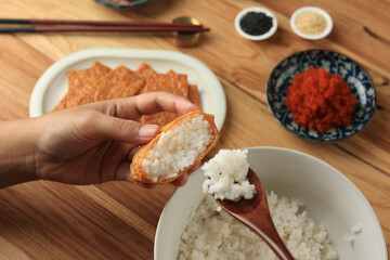 Close Up Female Hand Making Inari Sushi, Japanese Rice Wrapped in Tofu