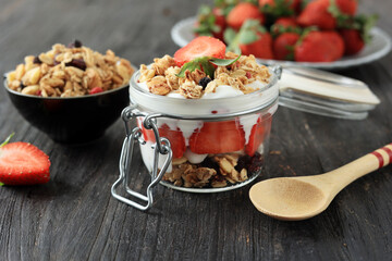 Strawberry Yogurt with Muesli on a Black Wooden Background