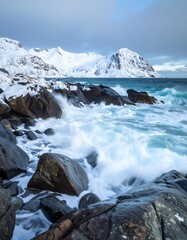 Dramatic coastal scene with crashing waves and snow-capped mountains