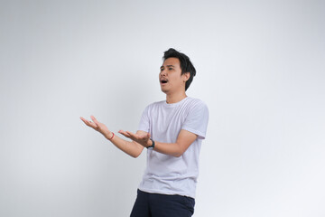 A young man in a white t-shirt expressing confusion or questioning with open hands gesture. Studio...