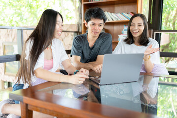 In a collaborative meeting, a Group of Asian male and female students use a laptop to research and share knowledge, aiming to strengthen their preparation for the challenges of the future.