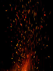 Fire sparks on black background for overlay effect and texture, perfect for adding warmth
