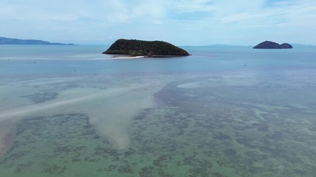 Aerial drone footage flying over Ko Tae Nai island near Koh Phangan, showcasing crystal clear waters, tropical coastline, and lush greenery.