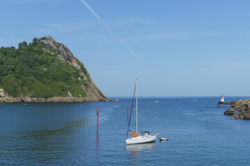 Sailboat anchored in Pasaia Bay with the La Plata lighthouse in the background, Basque Country