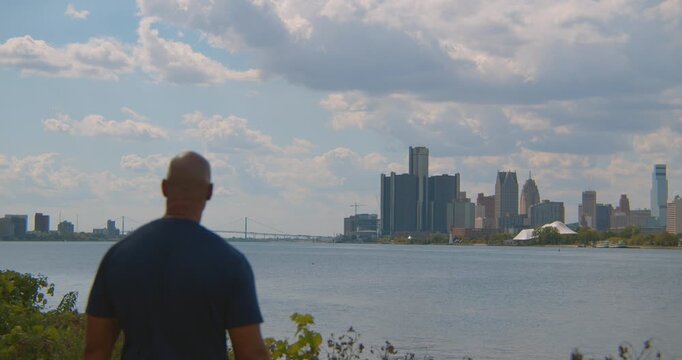 African American male takes in view of downtown downtown Detroit and the Detroit river