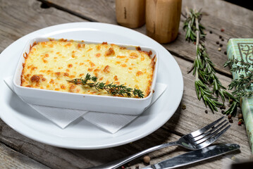 Cheese casserole in a ceramic dish on a wooden table with decor