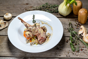 fried rabbit leg in cream sauce on a white plate