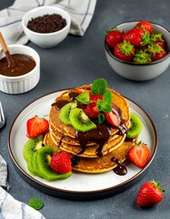 Delicious stacked pancakes with fruit and chocolate
