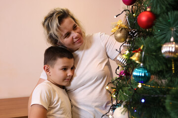 Mother and son decorating a Christmas tree. New Year's and Christmas holidays.