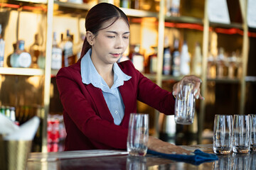 Asia woman cleaning a glass at bar	