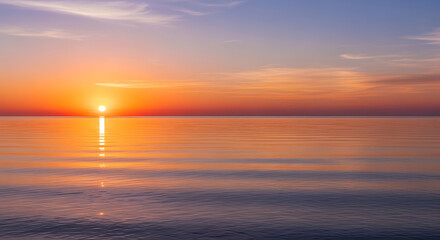 Fototapeta premium Vibrant sunset over the calm ocean with orange and purple hues