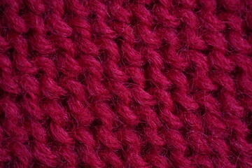 red Wool texture – red knitted fabric close-up Close-up texture of burgundy knitted wool fabric. Detailed symmetrical knit pattern. Soft textile background, suitable for fashion, crafts