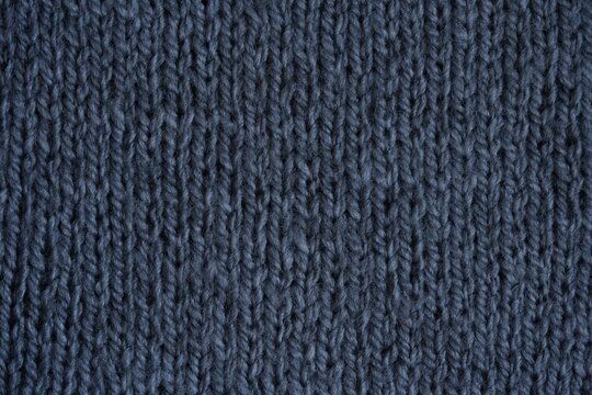 gray texture of knitted wool fabric as a background, grey smooth symmetrical lines of hand-knitted needlework pattern