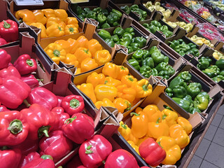 Fresh colorful bell peppers in market boxes, perfect for healthy food, nutrition, cooking, diet, and grocery themes.