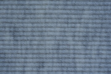gray texture of knitted synthetic cotton fabric as a background, grey smooth symmetrical lines of synthetic fabric	