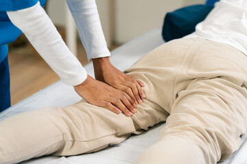 Fototapeta premium senior man doing exercise at clinic with physiotherapist. help of a personal trainer during a rehabilitation session.