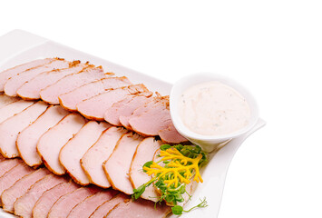 Sliced deli meat served with dipping sauce on a white platter