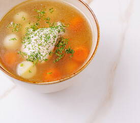 Homemade vegetable soup with carrots and herbs in a bowl