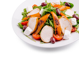 Grilled chicken and peach salad with feta cheese and olives on a plate