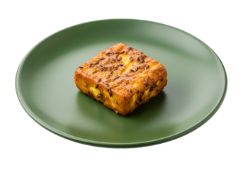 A crispy, golden-brown cheese cube, studded with seeds, sits on a vibrant green plate against a dark backdrop.