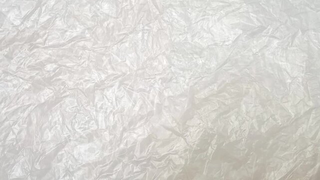 White crumpled plastic bag texture background rotating. Real Low-Density Polyethylene shopping bag. LDPE shopper texture. vertical clip