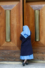 Catholic nun opening a door.  Rome. Italy.