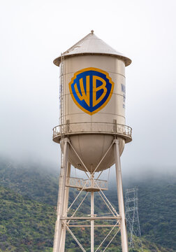 Burbank, USA, Mar 12, 2023 &ndash; The iconic Warner Bros. water tower featuring the WB logotype on the studio lot in California, with low clouds and green hills in the background.