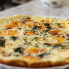A a savory omelette with orange tomatoes, bell peppers, herbs, and pieces of ham