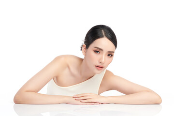 Fototapeta premium A beautiful young Asian woman with clean, fresh skin against a white background. Skincare, facial treatment, cosmetology, beauty, and spa. An elegant portrait of an Asian woman.