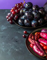 Fresh purple fruits and vegetables on dark surface