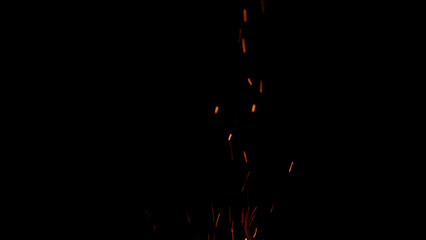 sparks and embers from campfire flying over black background