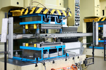 Cold metal stamping and pressing production line with precision machinery in operation at a manufacturing facility