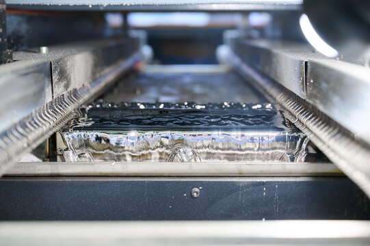 Wave soldering process for PCB tinning in a molten solder bath within an industrial setting