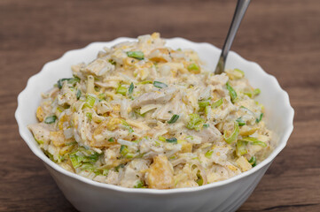 Party salad with boiled rice and chicken, peaches and leek in mayonnaise sauce