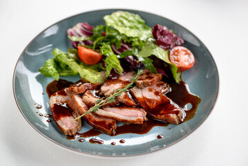 salad with tomatoes and meat in teriyaki sauce on a white background